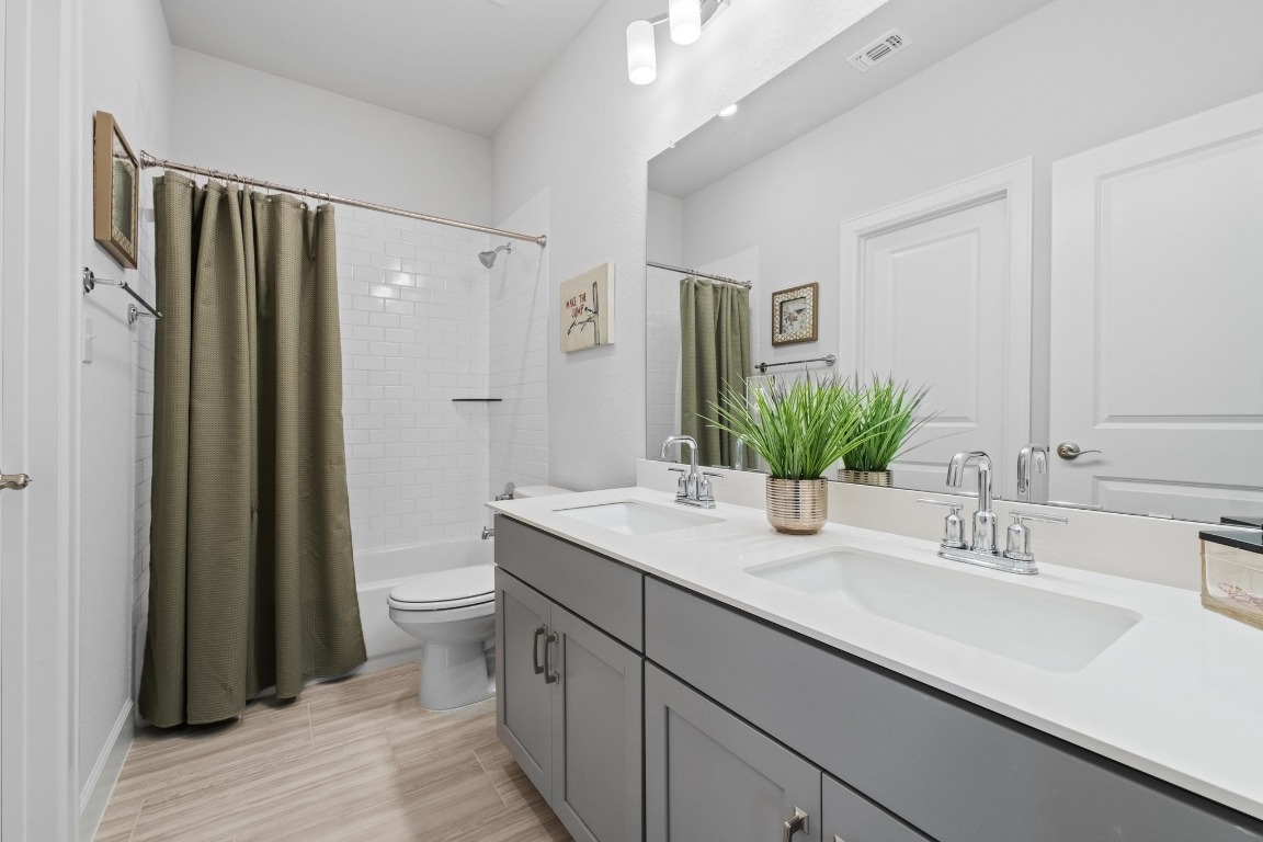144 Monterey Oak Trail Georgetown, TX 78628 - Photo 18 of 28 a bathroom with a double vanity sink toilet and shower