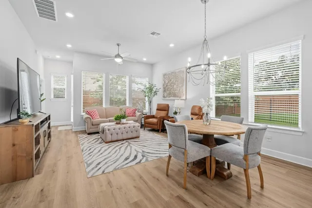 a living room with furniture a flat screen tv and large windows