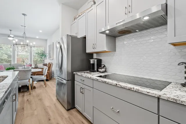 a kitchen with a sink dishwasher a refrigerator and cabinets