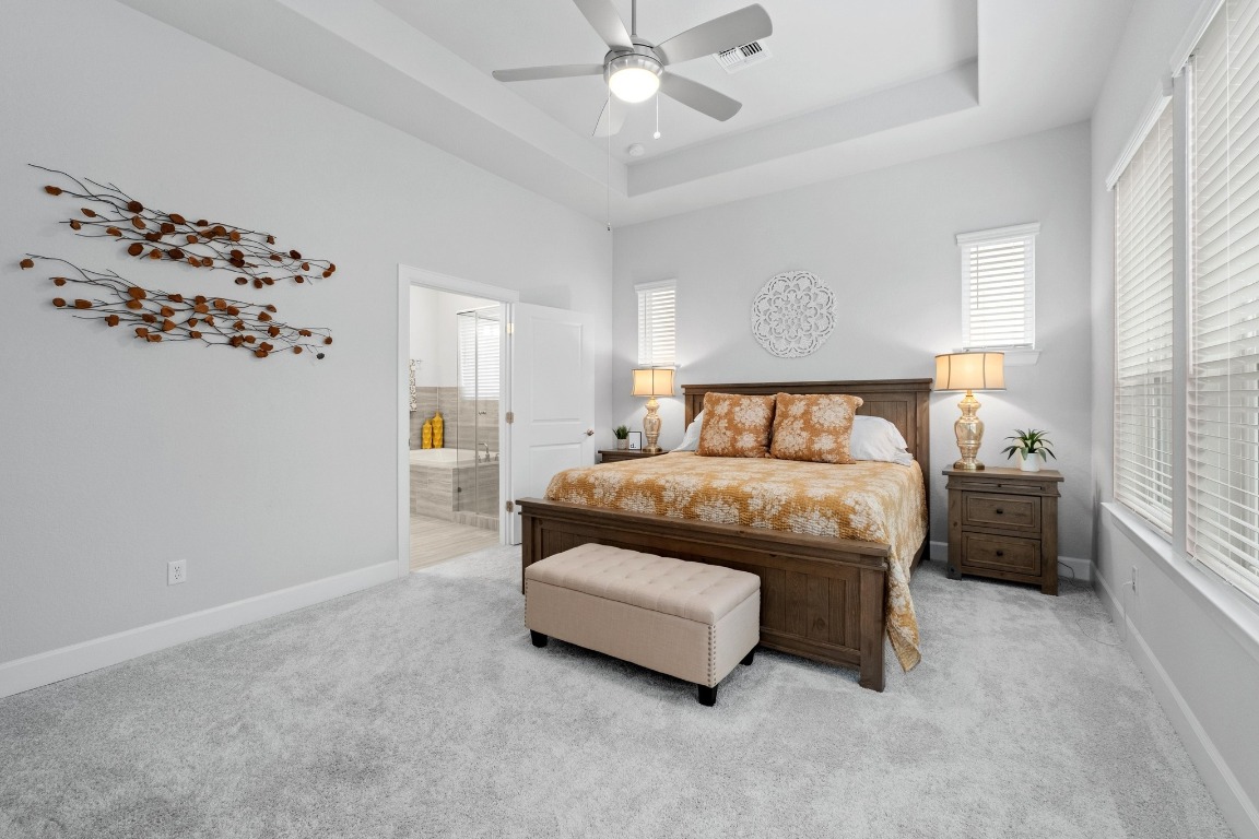 144 Monterey Oak Trail Georgetown, TX 78628 - Photo 10 of 28 a bedroom with a bed and a chandelier