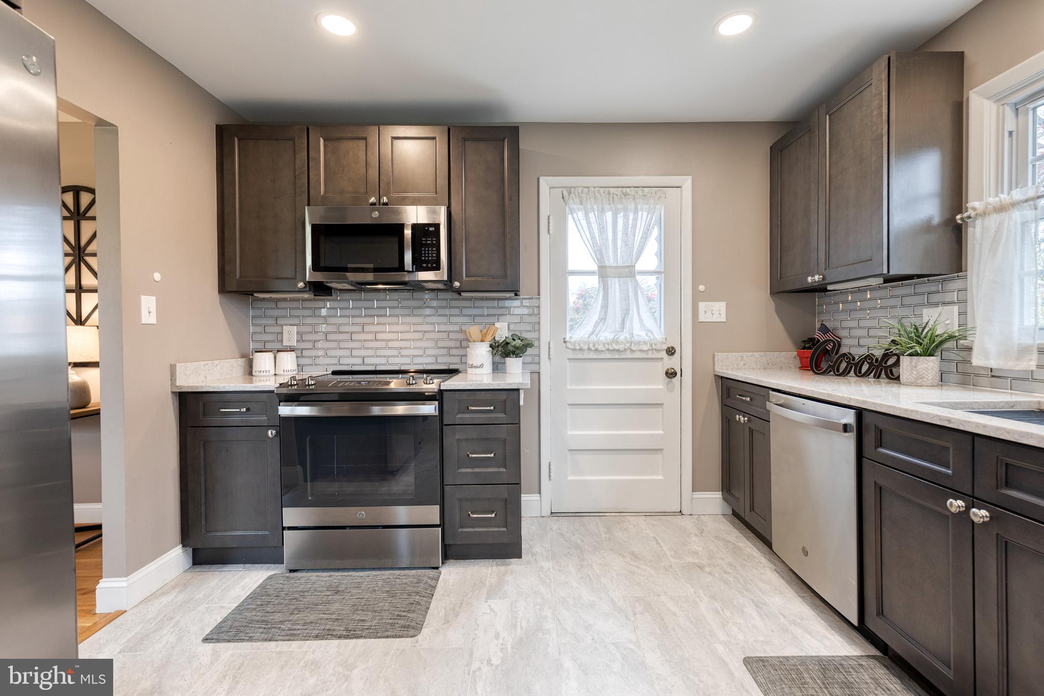 1302 Black Friars Road Baltimore, MD 21228 - Photo 14 of 38 a kitchen with granite countertop a stove and a sink