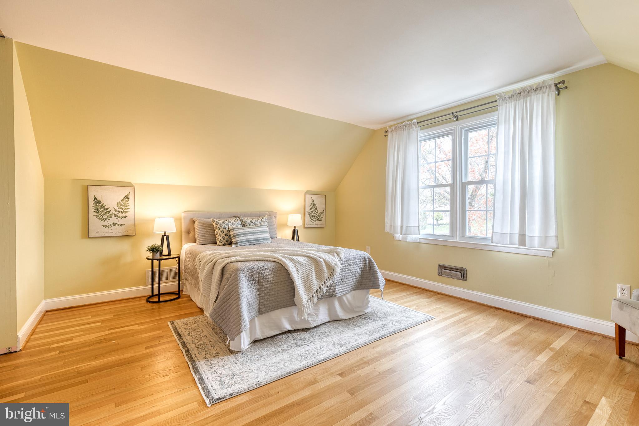 1302 Black Friars Road Baltimore, MD 21228 - Photo 21 of 38 a spacious bedroom with a bed and wooden floor