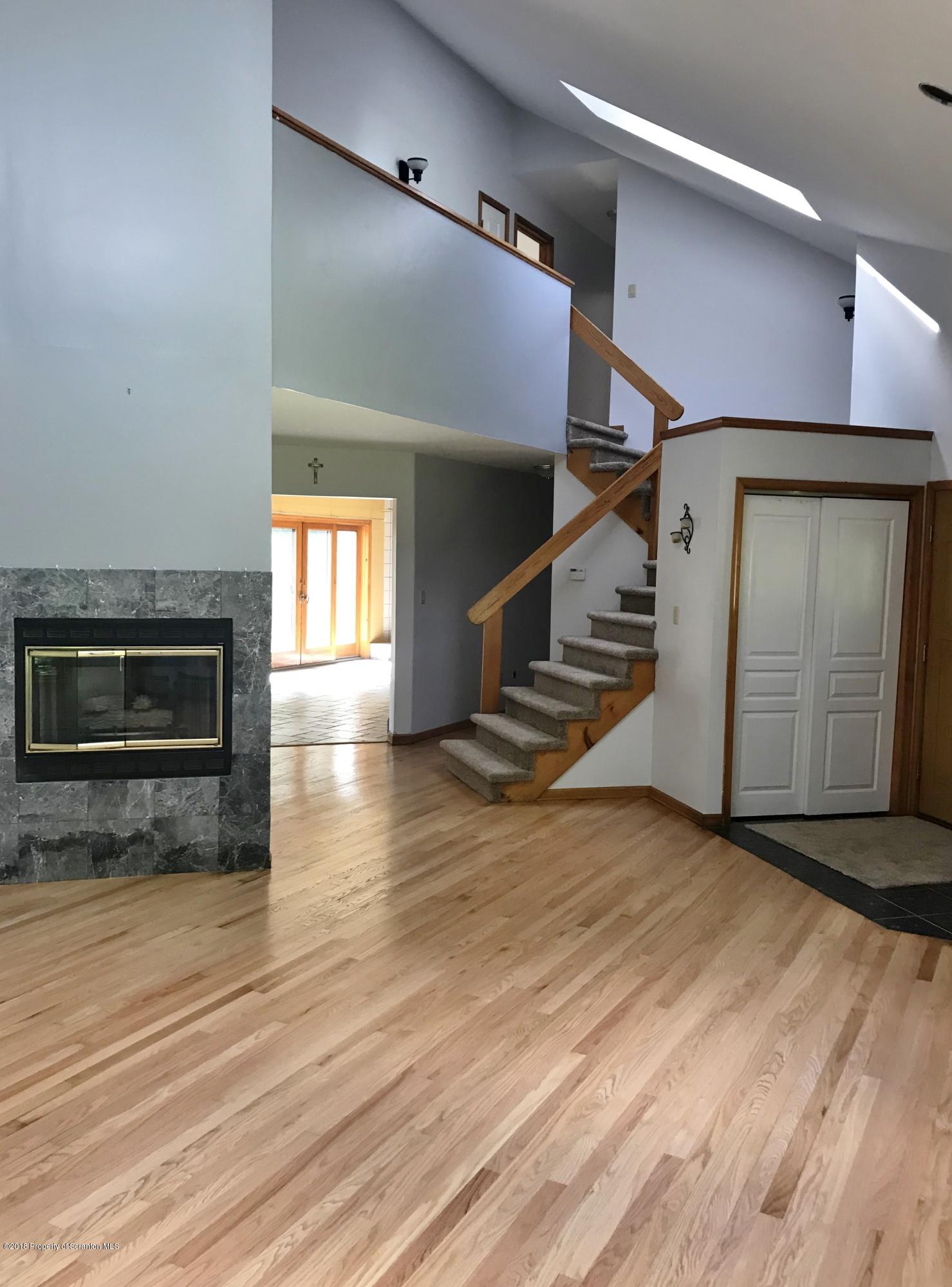 20 Ridgeview Drive Scranton, PA 18504 - Photo 5 of 39 a view of an empty room with wooden floor fireplace and a window