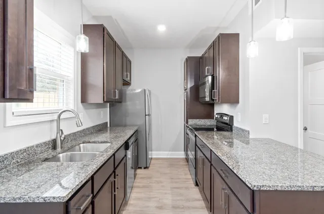 a kitchen with stainless steel appliances granite countertop a sink stove and refrigerator