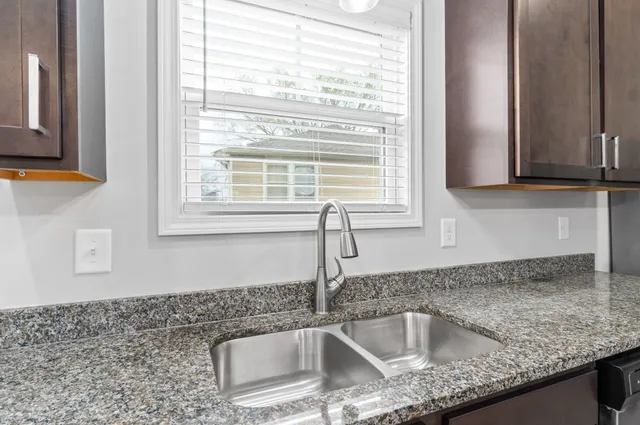 a kitchen with granite countertop a sink and a window