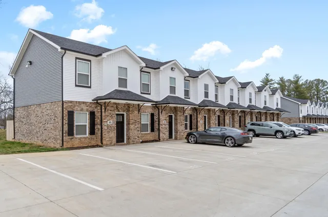 a couple of cars parked in front of a white building