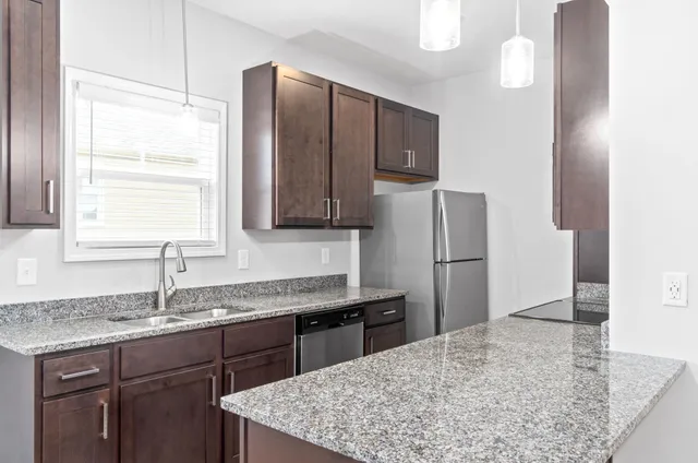 a kitchen with stainless steel appliances granite countertop a sink refrigerator and microwave