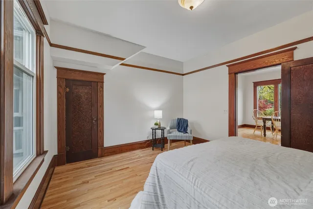 a bedroom with a bed and a large mirror next to a window