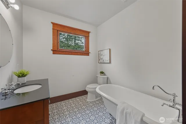 a bathroom with a granite countertop bathtub sink and toilet