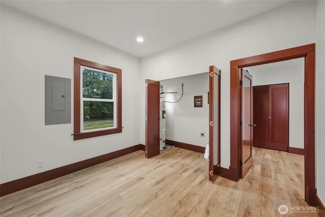 a view of an empty room with wooden floor and a window