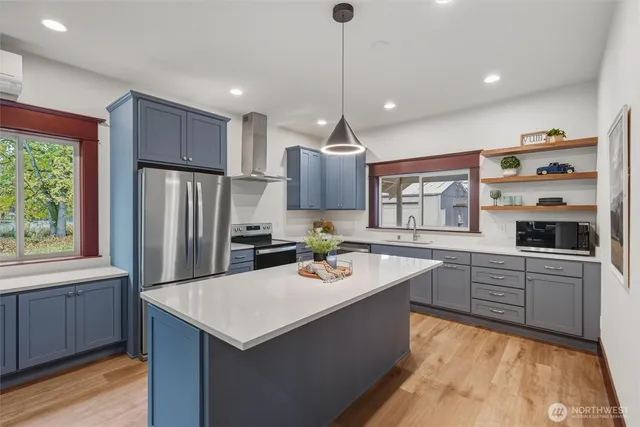 a kitchen with a refrigerator a sink dishwasher and wooden cabinets with wooden floor