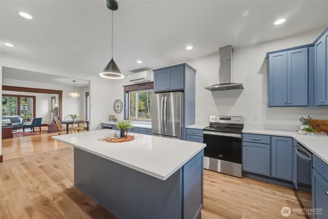 a kitchen with a stove a refrigerator and wooden floor
