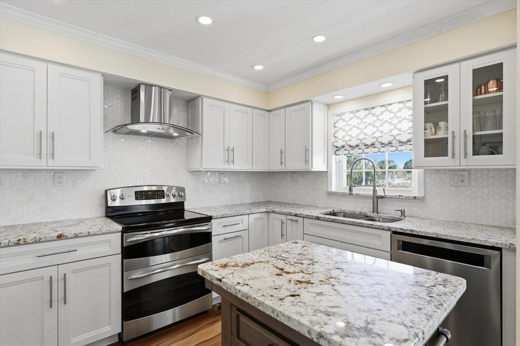 9170 Blind Pass Road St. Pete Beach, FL 33706 - Photo 15 of 58 a kitchen with kitchen island a sink stove and window