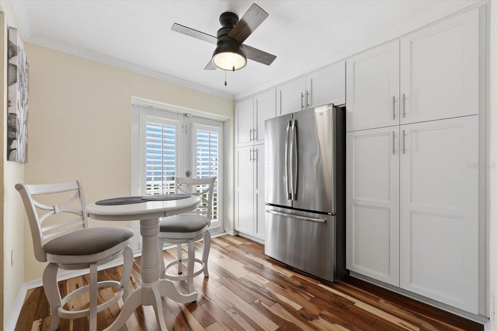 9170 Blind Pass Road St. Pete Beach, FL 33706 - Photo 17 of 58 a kitchen with stainless steel appliances granite countertop a refrigerator a stove a dining table and chairs with wooden floor