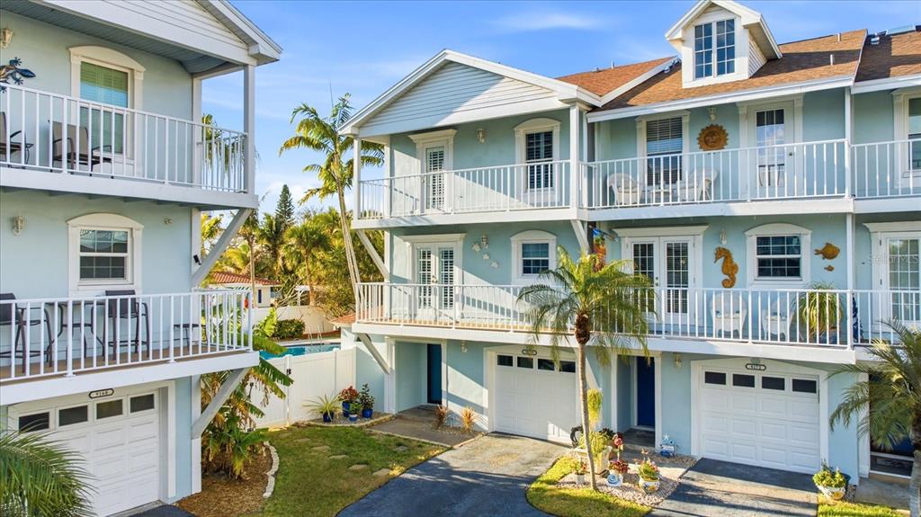 9170 Blind Pass Road St. Pete Beach, FL 33706 - Photo 2 of 58 a front view of a residential apartment building with a yard