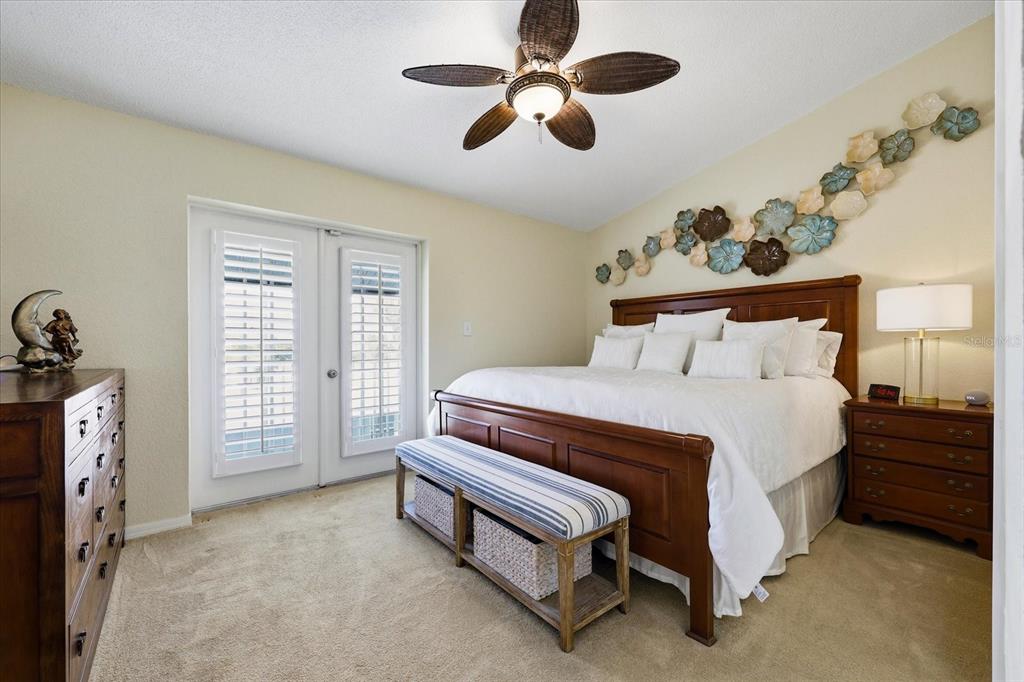 9170 Blind Pass Road St. Pete Beach, FL 33706 - Photo 22 of 58 a bedroom with a bed and a chandelier