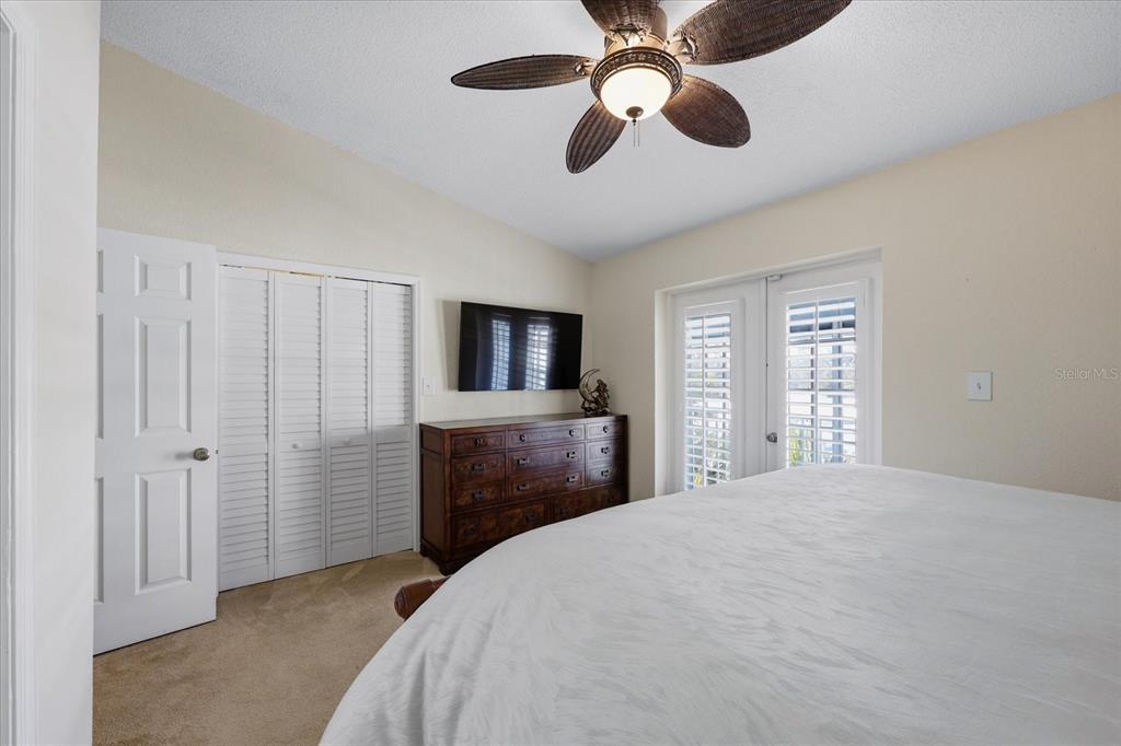 9170 Blind Pass Road St. Pete Beach, FL 33706 - Photo 23 of 58 a bedroom with a bed and a flat screen tv