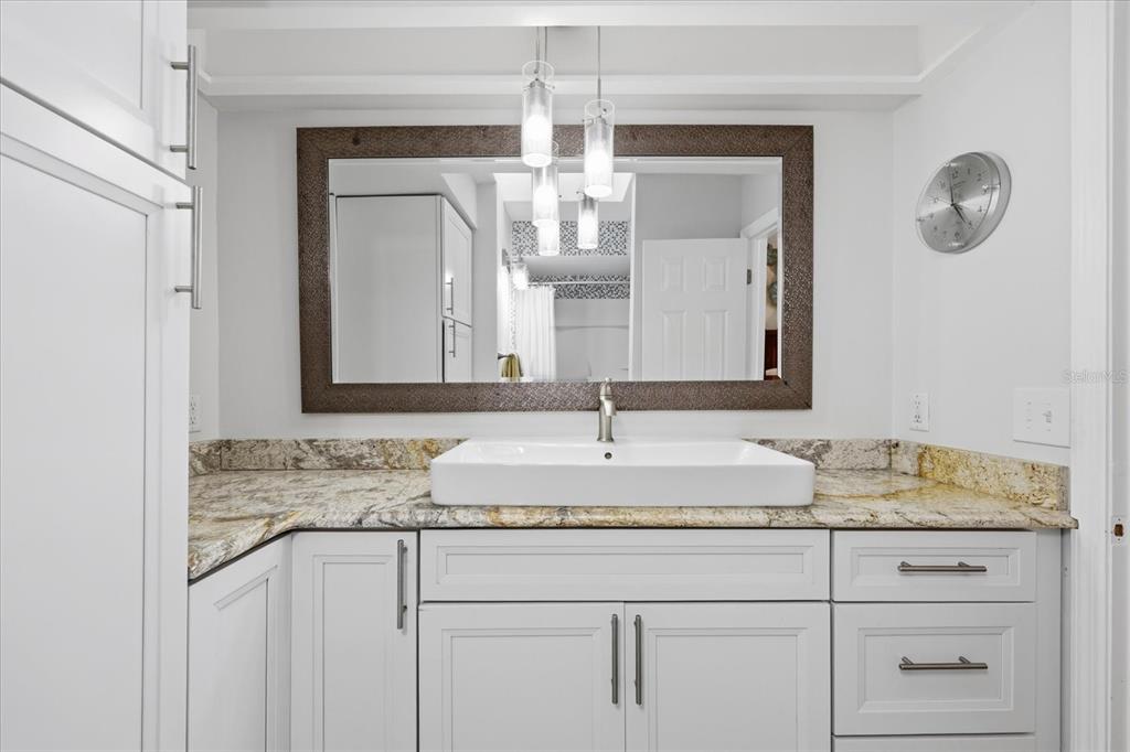 9170 Blind Pass Road St. Pete Beach, FL 33706 - Photo 24 of 58 a bathroom with a granite countertop sink and a mirror