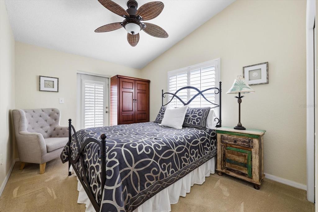 9170 Blind Pass Road St. Pete Beach, FL 33706 - Photo 32 of 58 a bedroom with a bed and ceiling fan