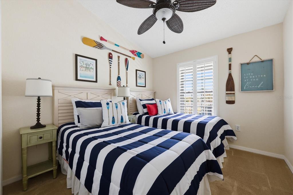 9170 Blind Pass Road St. Pete Beach, FL 33706 - Photo 34 of 58 a bedroom with a bed and a chandelier