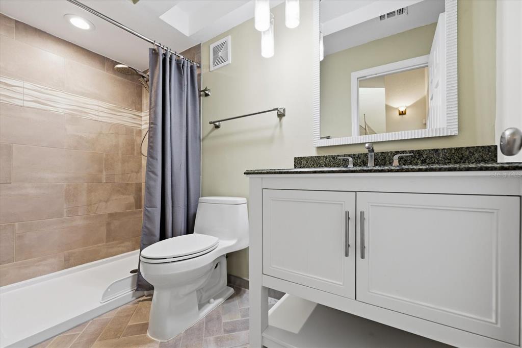 9170 Blind Pass Road St. Pete Beach, FL 33706 - Photo 35 of 58 a bathroom with a granite countertop sink toilet and shower