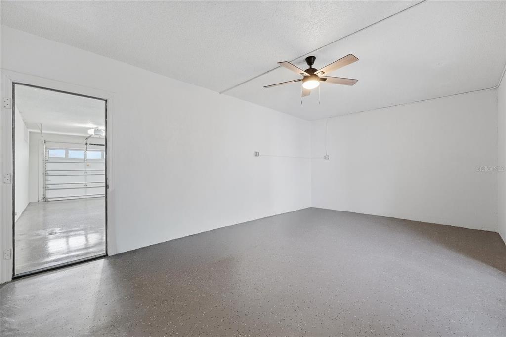9170 Blind Pass Road St. Pete Beach, FL 33706 - Photo 36 of 58 an empty room with a ceiling fan and wooden floor
