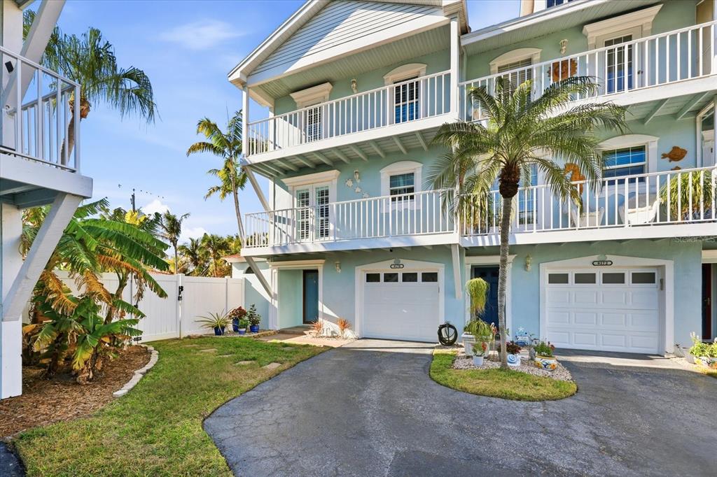 9170 Blind Pass Road St. Pete Beach, FL 33706 - Photo 40 of 58 a front view of multi story residential apartment building with yard and seating area