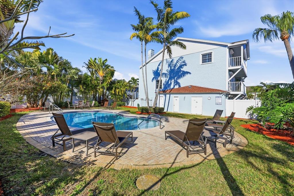 9170 Blind Pass Road St. Pete Beach, FL 33706 - Photo 41 of 58 a view of a patio with table and chairs potted plants and large tree