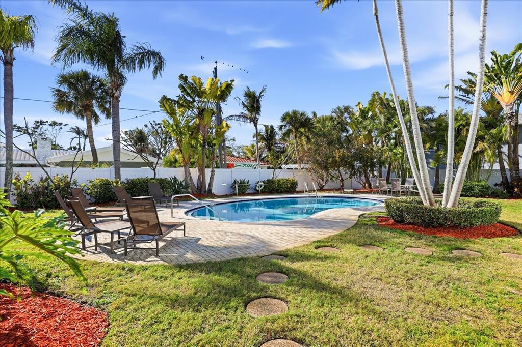 9170 Blind Pass Road St. Pete Beach, FL 33706 - Photo 5 of 58 a view of a swimming pool with a lounge chairs