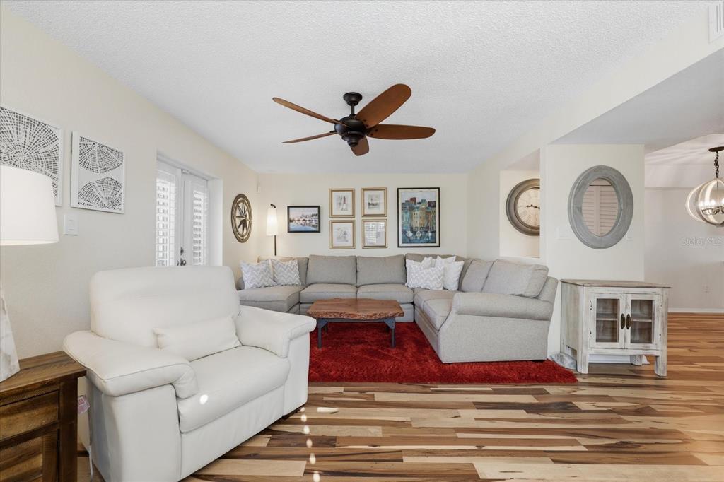 9170 Blind Pass Road St. Pete Beach, FL 33706 - Photo 9 of 58 a living room with furniture a clock on wall and a window
