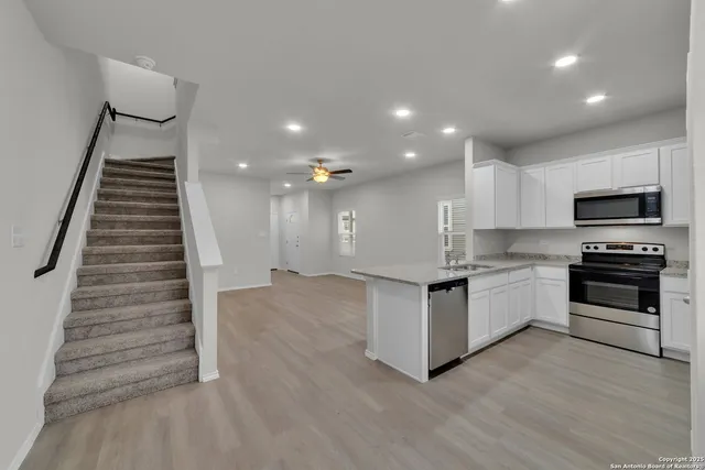 a kitchen with granite countertop a stove and a wooden floors