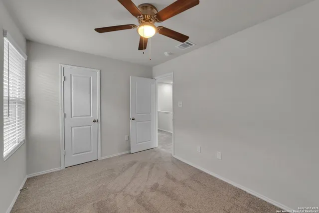 an empty room with chandelier fan