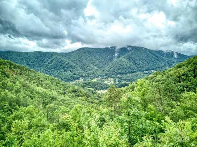 a view of a balcony with wooden floor and a floor to ceiling window