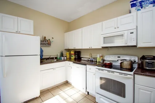 a kitchen with stainless steel appliances granite countertop a sink a stove a refrigerator and cabinets