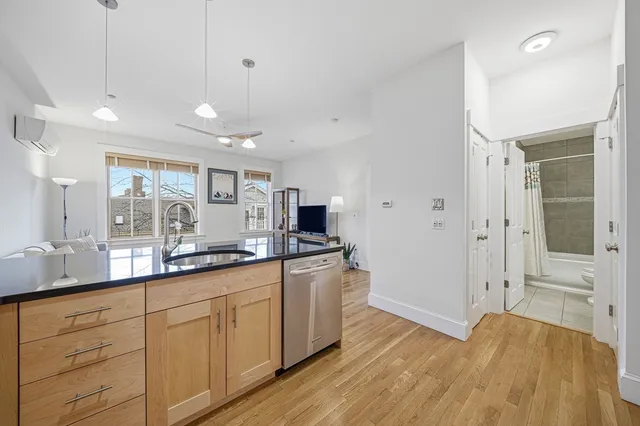 a kitchen with stainless steel appliances granite countertop a sink and wooden floor