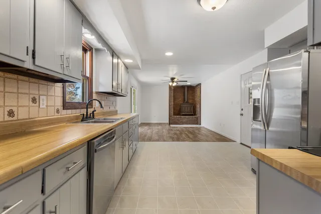 a large kitchen with kitchen island a sink stainless steel appliances and cabinets