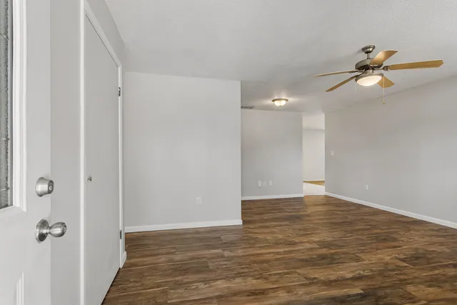 a view of a room with wooden floor and fan