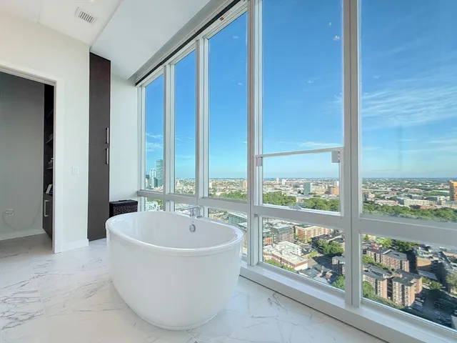a white bath tub sitting in a bathroom next to a window