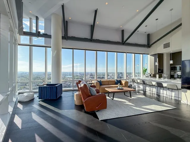 a living room with furniture and floor to ceiling windows
