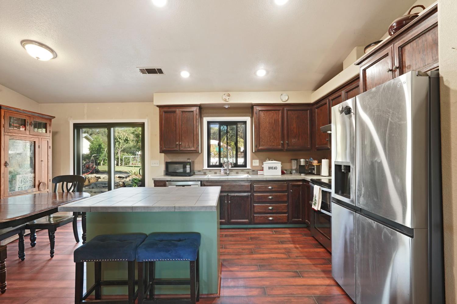 7505 Baldwin Street Valley Springs, CA 95252 - Photo 13 of 45 a kitchen with granite countertop a refrigerator and wooden cabinets