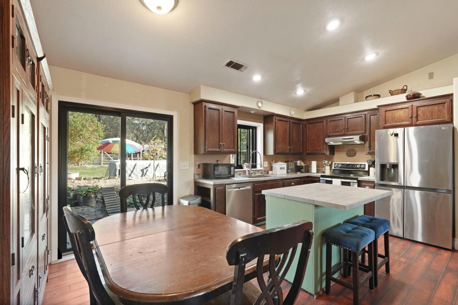 7505 Baldwin Street Valley Springs, CA 95252 - Photo 14 of 45 a kitchen with refrigerator a stove and dining table
