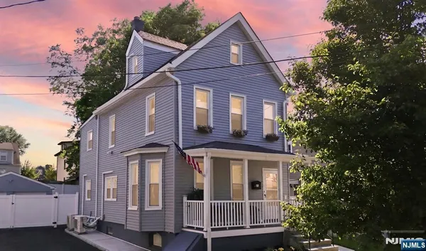 a front view of a house with a tree
