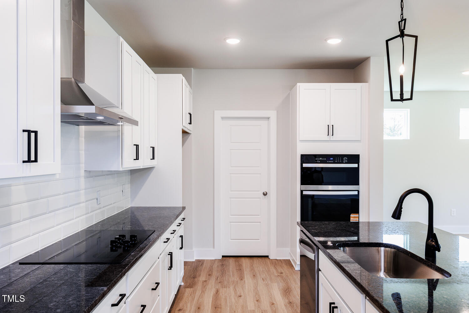 a kitchen with stainless steel appliances a sink dishwasher a refrigerator and wooden cabinets with wooden floor