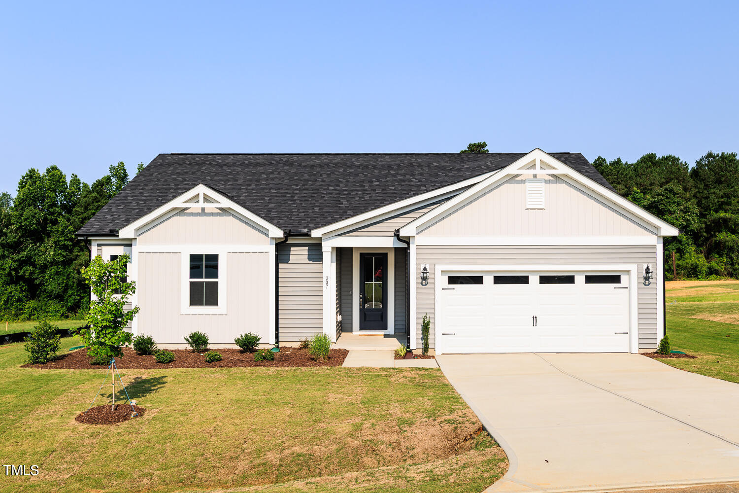 207 Golfview Avenue Four Oaks, NC 27524 - Photo 2 of 37 a view of a white house with a yard and plants