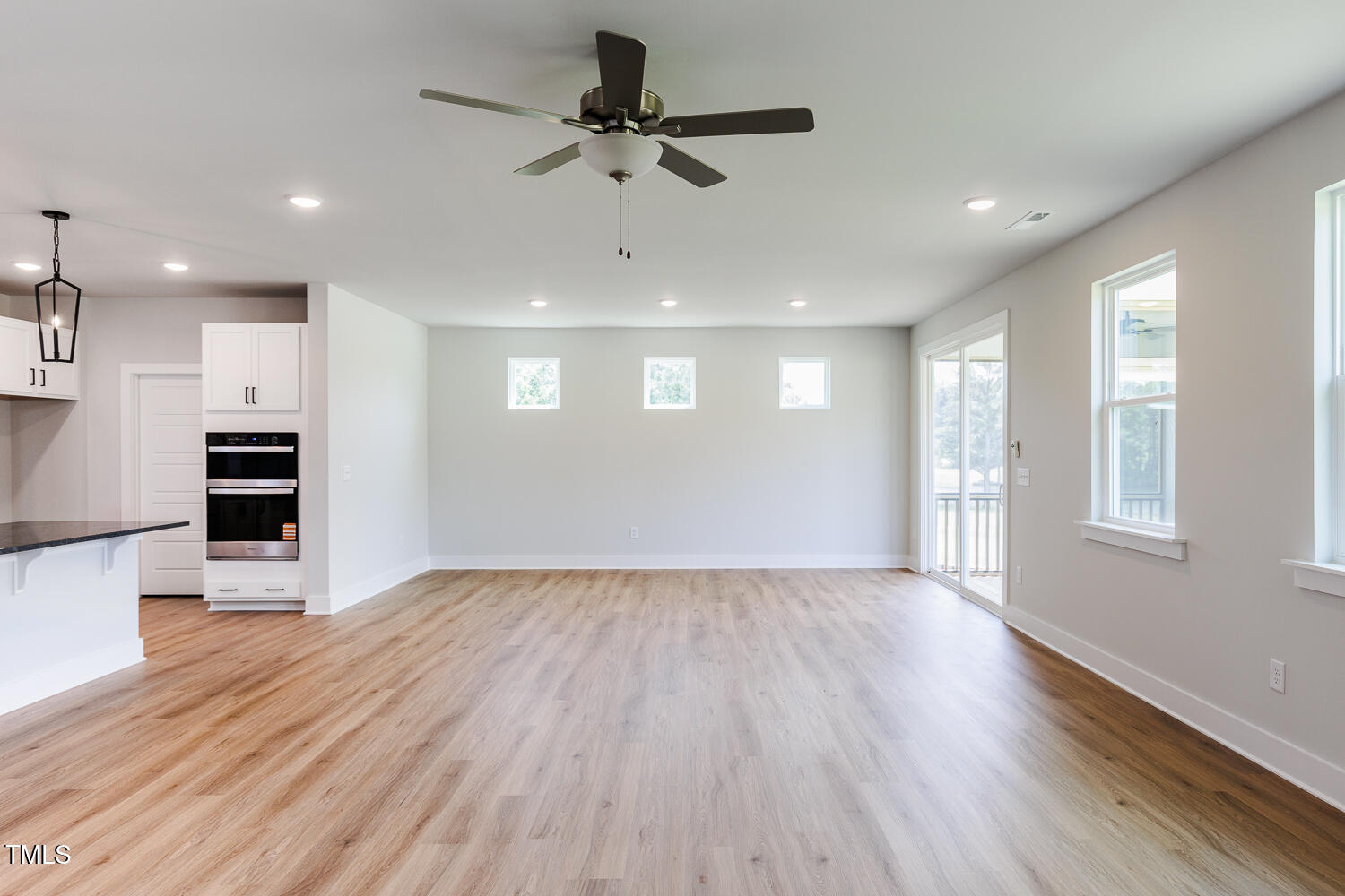 207 Golfview Avenue Four Oaks, NC 27524 - Photo 9 of 37 a view of kitchen and empty room with wooden floor