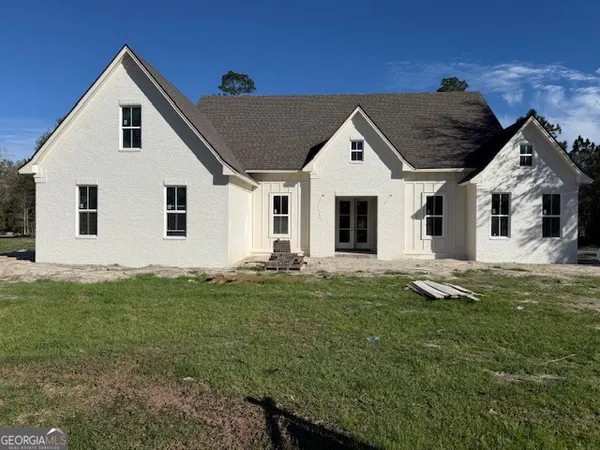 a front view of a house with a garden