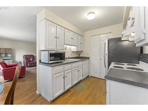 a kitchen with stainless steel appliances granite countertop a stove a sink and a microwave
