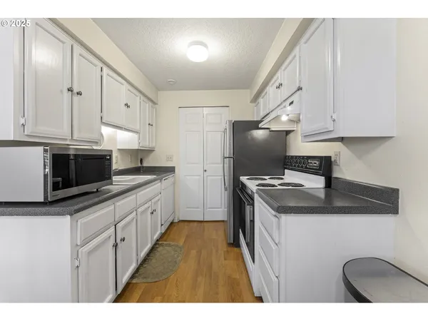 a kitchen with stainless steel appliances granite countertop a sink stove and cabinets