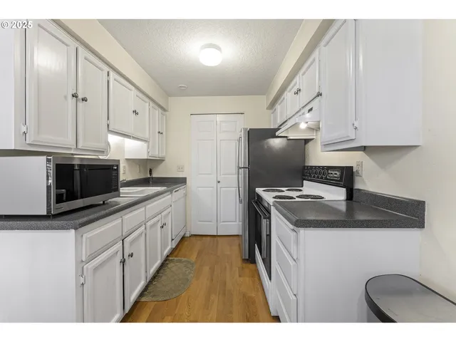 a kitchen with stainless steel appliances granite countertop a sink stove and cabinets