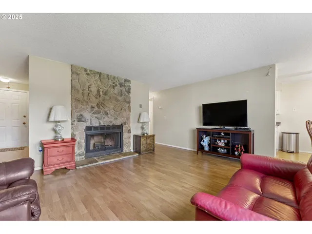 a living room with furniture a flat screen tv and a fireplace